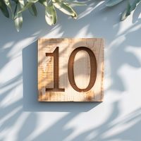 Holzschild mit der Zahl „10“ als Symbol für eine 10er-Karte für offene Stunden.